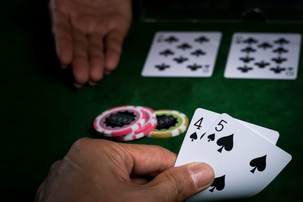 Player reveals hand of baccarat totalling nine points.