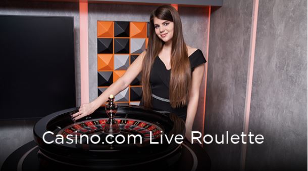 Female live roulette dealer next to the wheel.