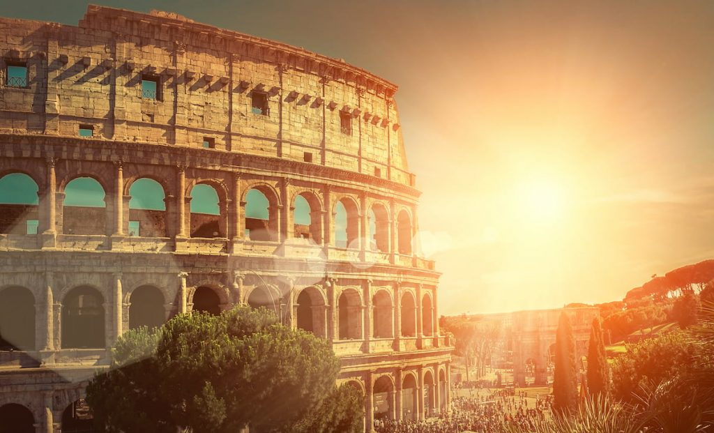The sun sets behind the Colosseum