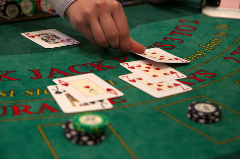 Dealer menempatkan kartu blackjack di atas meja.