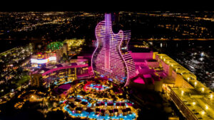 The Hard Rock Hotel in Florida at night, lit up by pink neon lights