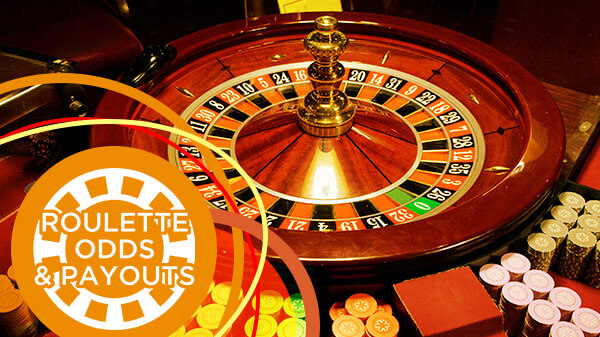 Wooden roulette wheel next to stacks of betting chips.