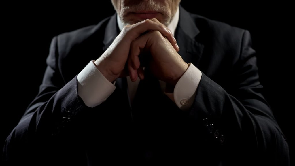 Billionaire businessman with arms folded.