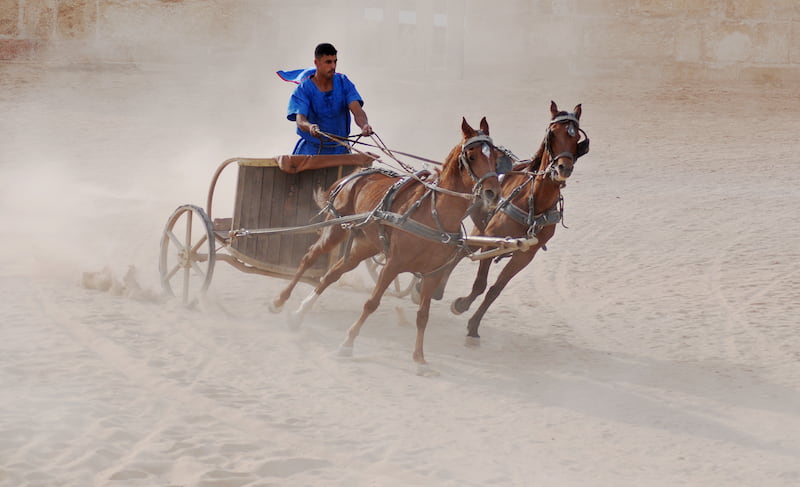 Man riding a chariot pulled by horses