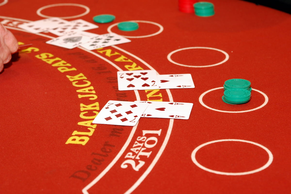 Red blackjack table with cards face up.