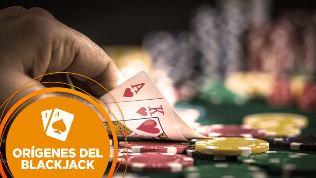 Un jugador mira las cartas de blackjack para revelar el as y el rey de corazones.