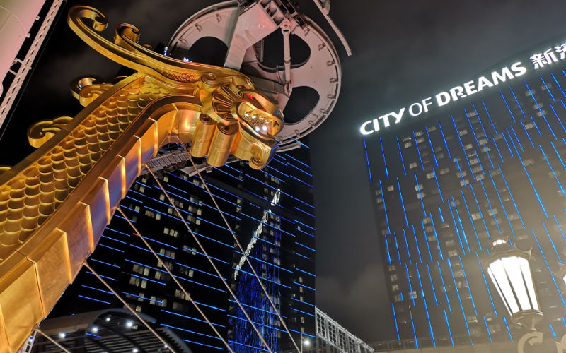 A view of the City of Dreams in Macau from below with an ornamental golden dragon in the foreground