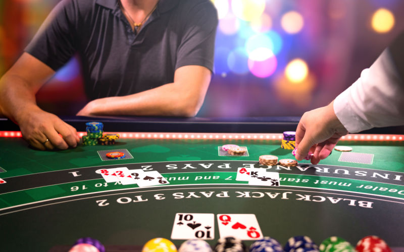 A man playing black jack in a darkly lit casino