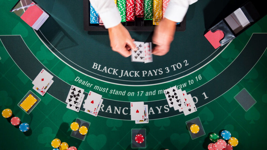 An over head view of a dealer using many decks in blackjack