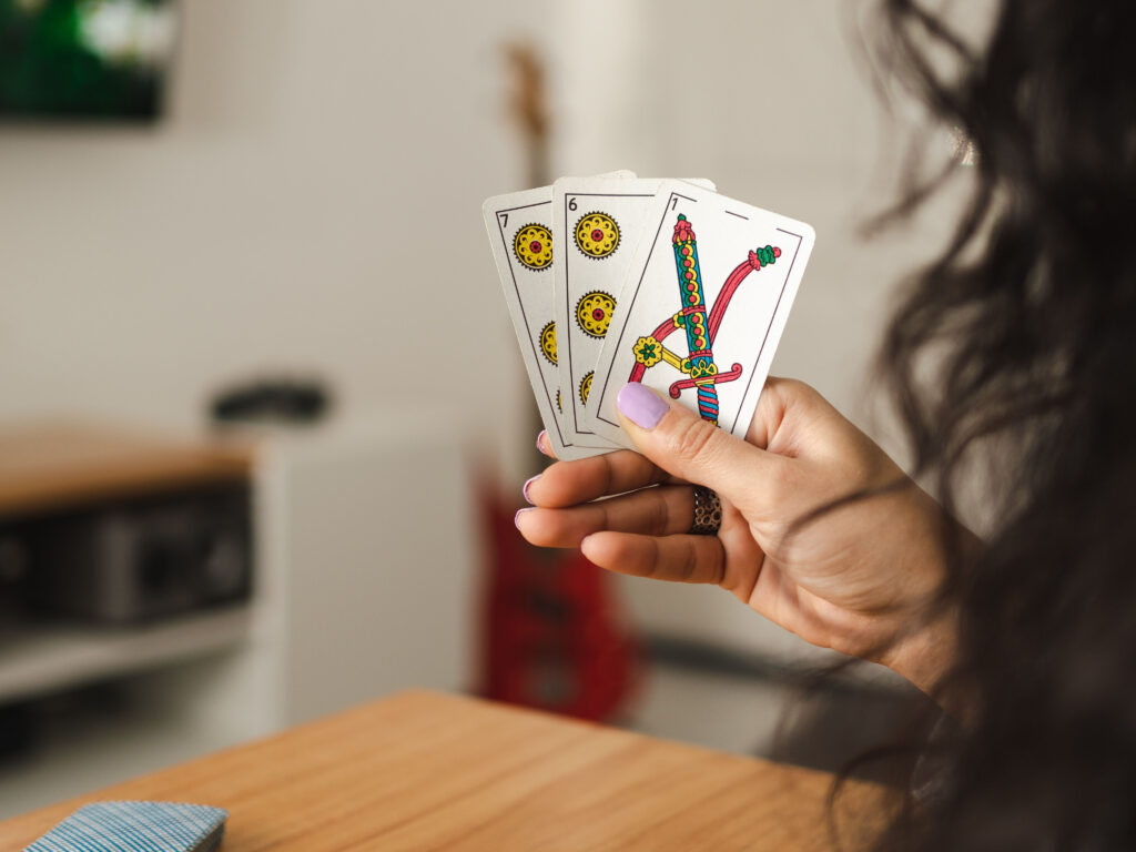 A view over the shoulder of a woman playing Truco