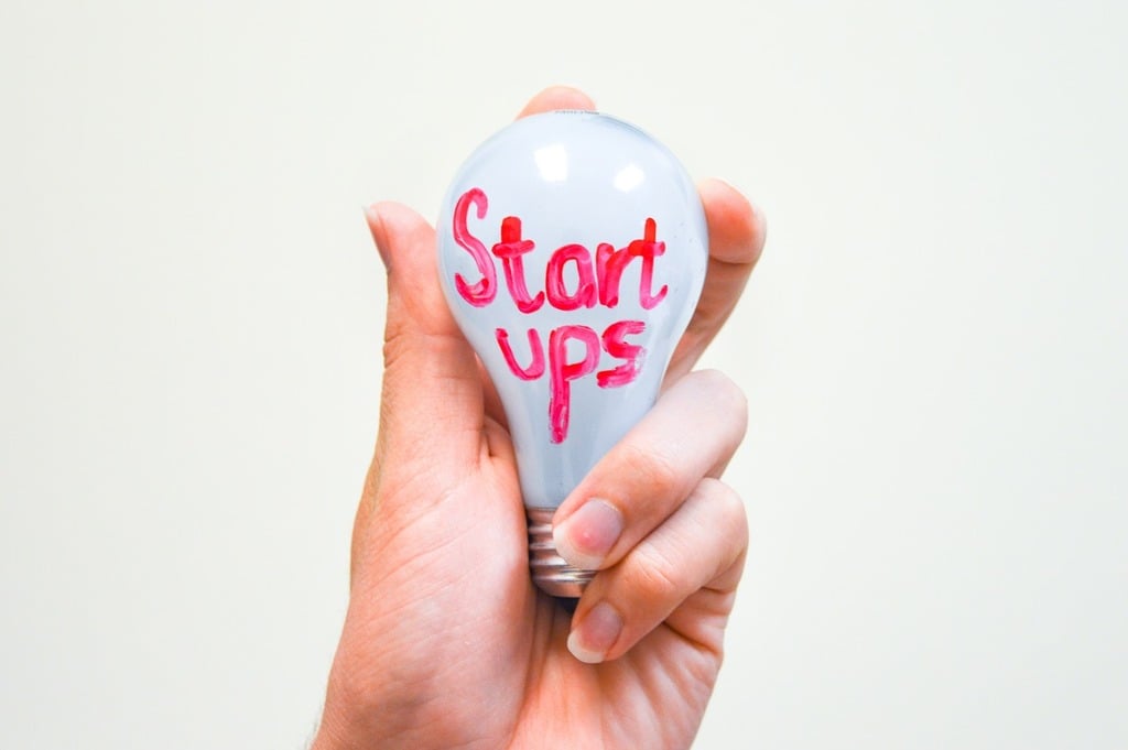 lightbulb startups an image of a hand holding a lightbulb with the word startup written in red