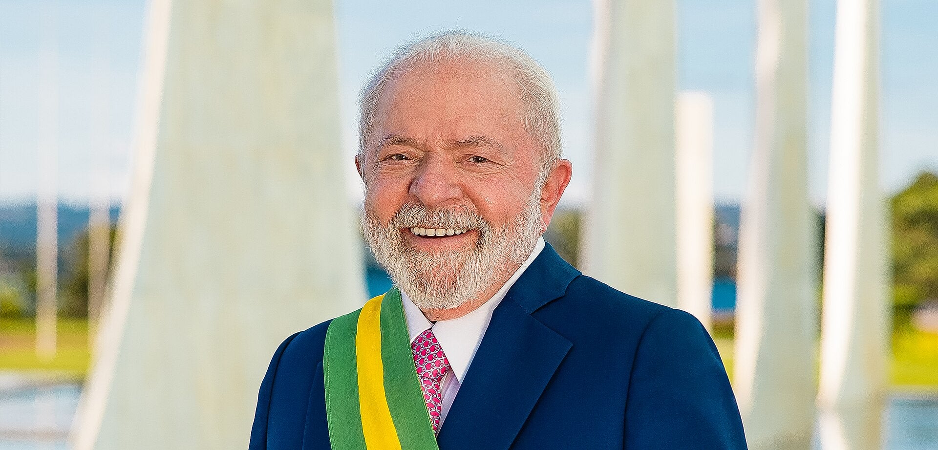 Brazilian President Luiz Inácio Lula da Silva smiling in a navy suit and green and yellow presidential sash
