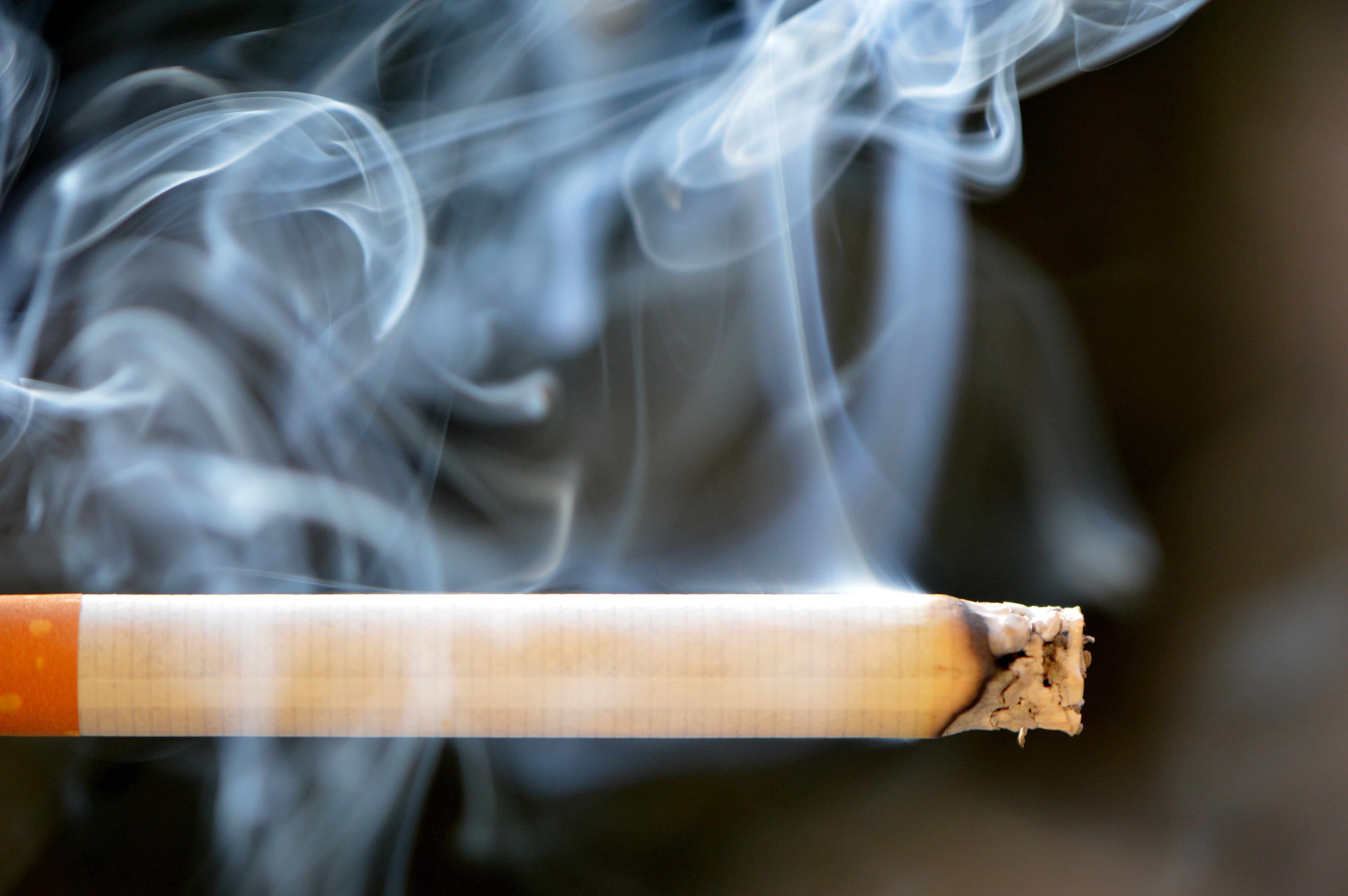 Nevada Cigarette Tax Hike: Coalition Proposes $3.55/Pack Lit cigarette with smoke rising, representing Nevada's proposed cigarette tax increase