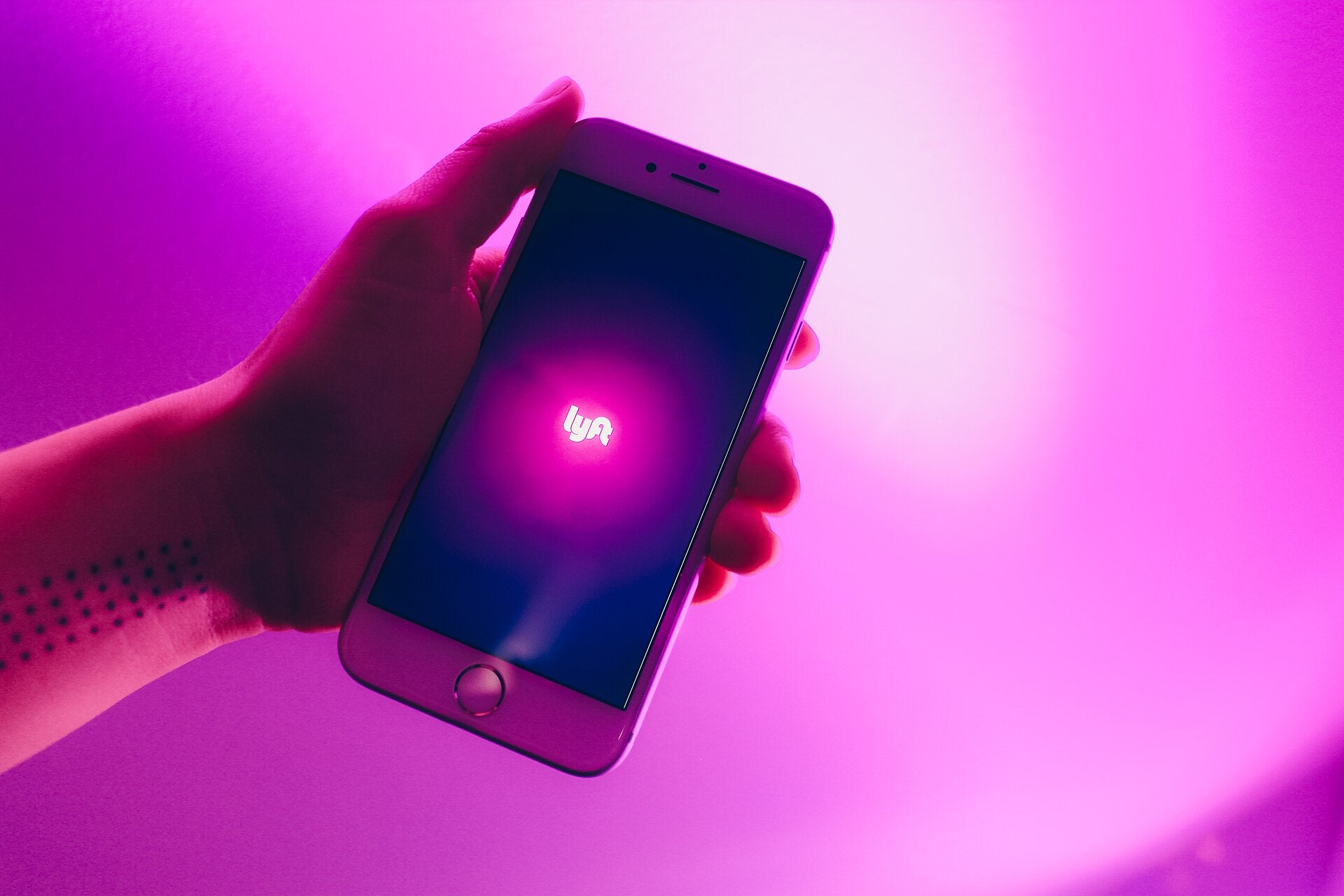 Hand holding smartphone with Lyft app open, representing Sphere Las Vegas and Lyft rideshare partnership