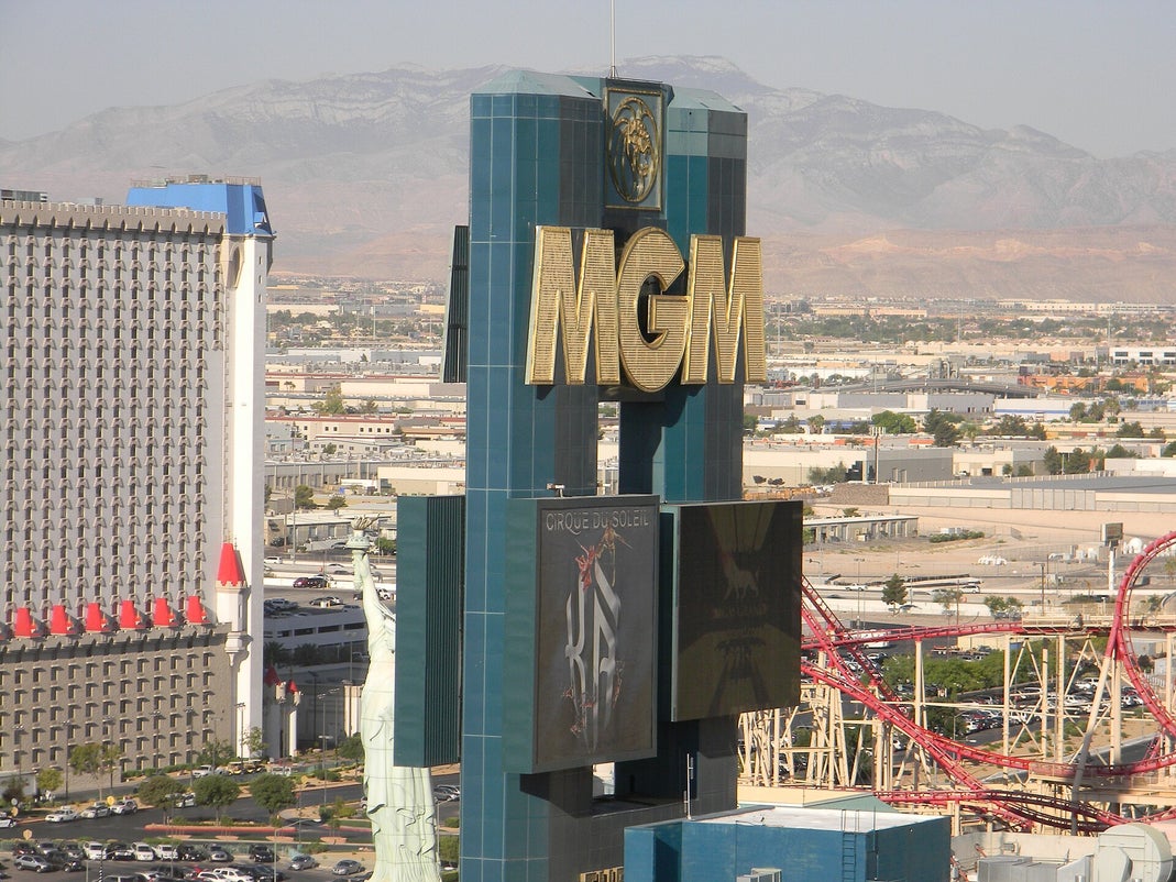 MGM Grand hotel front sign in Las Vegas with the Strip and mountains in the background
