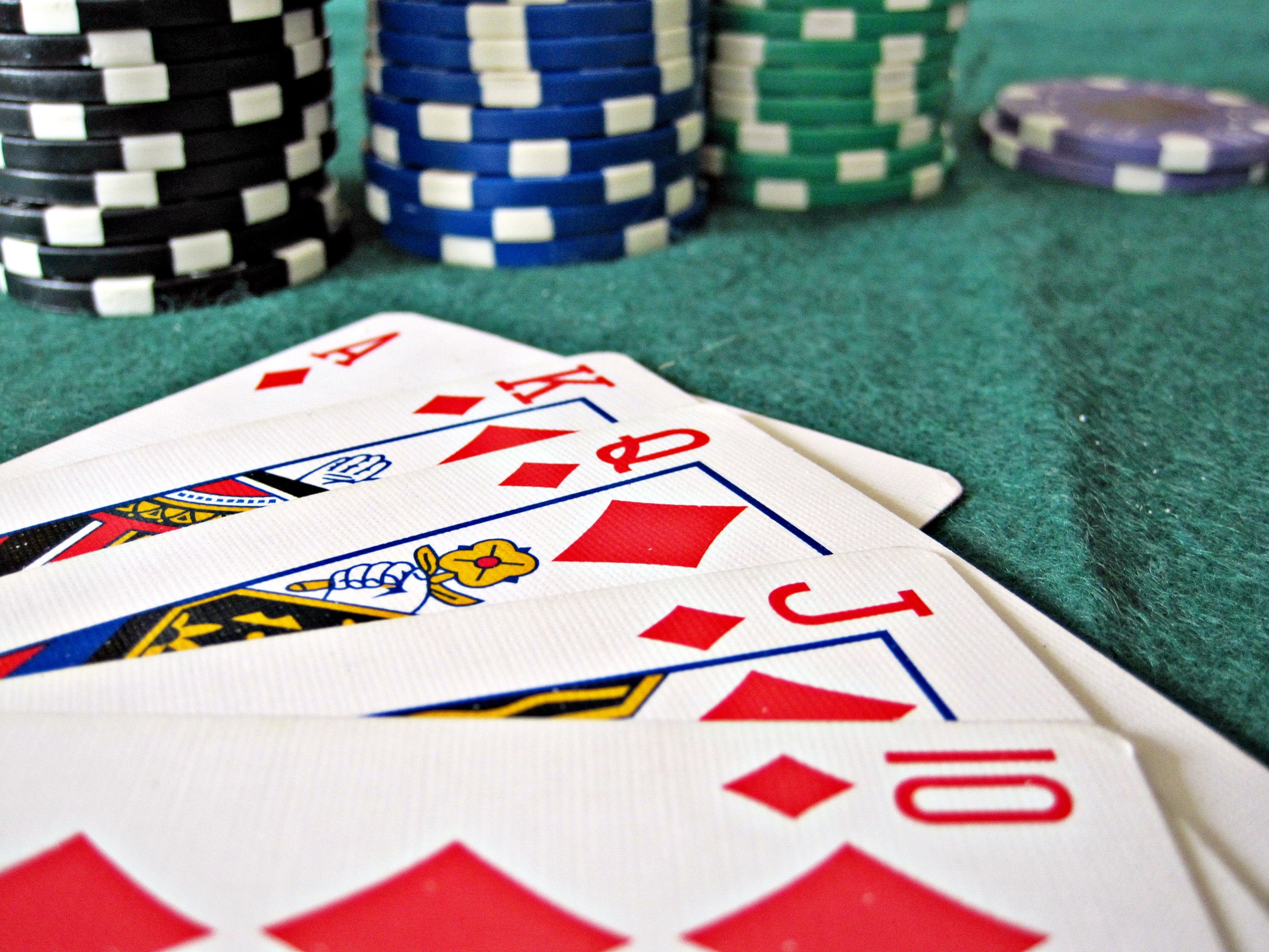 Casino chips and playing cards on a green felt table
