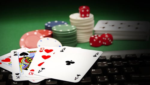 Alberta iGaming Market Launches with 20+ Operators Playing cards, poker chips, and dice on a keyboard, representing Alberta's regulated online gambling market