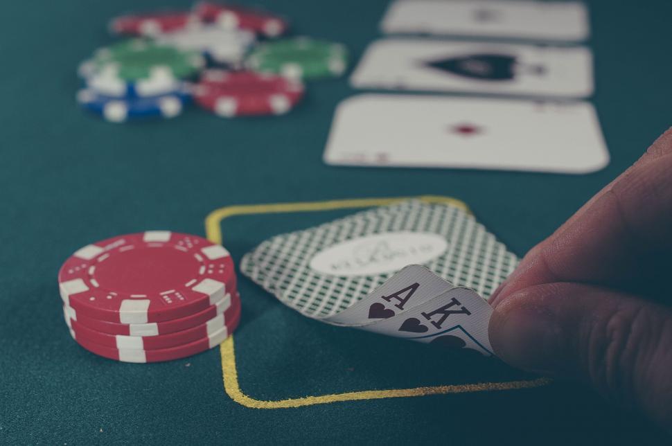 A player peeks at an ace-king hand on a poker table during a casino game