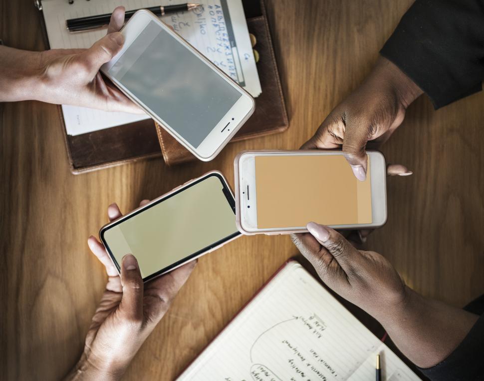 Close up of people touching mobile phone screens