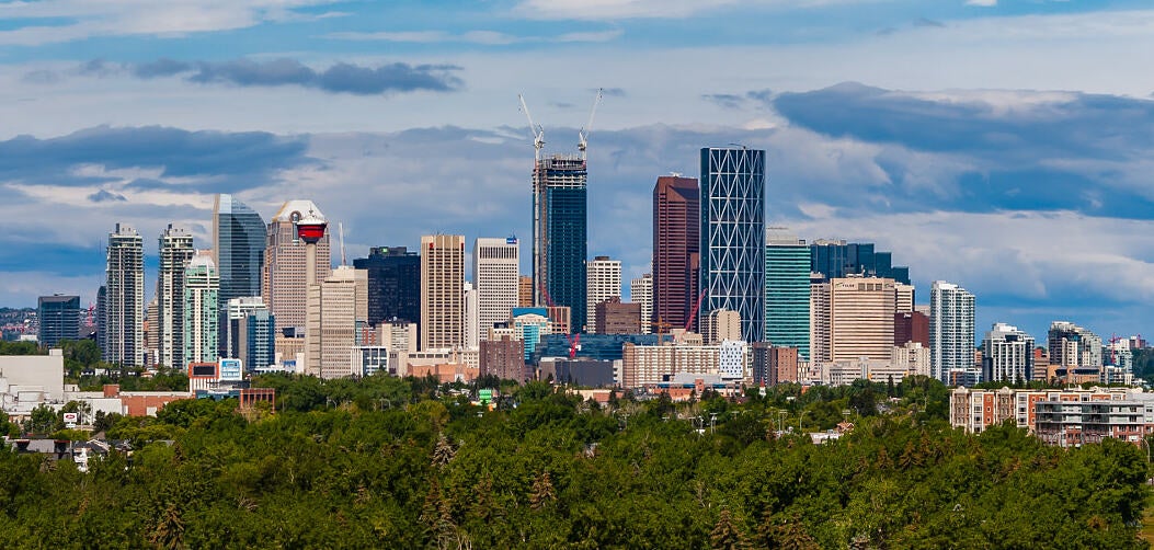Panoramic view of Calgary skyline with downtown skyscrapers and cloudy sky in Alberta, Canada