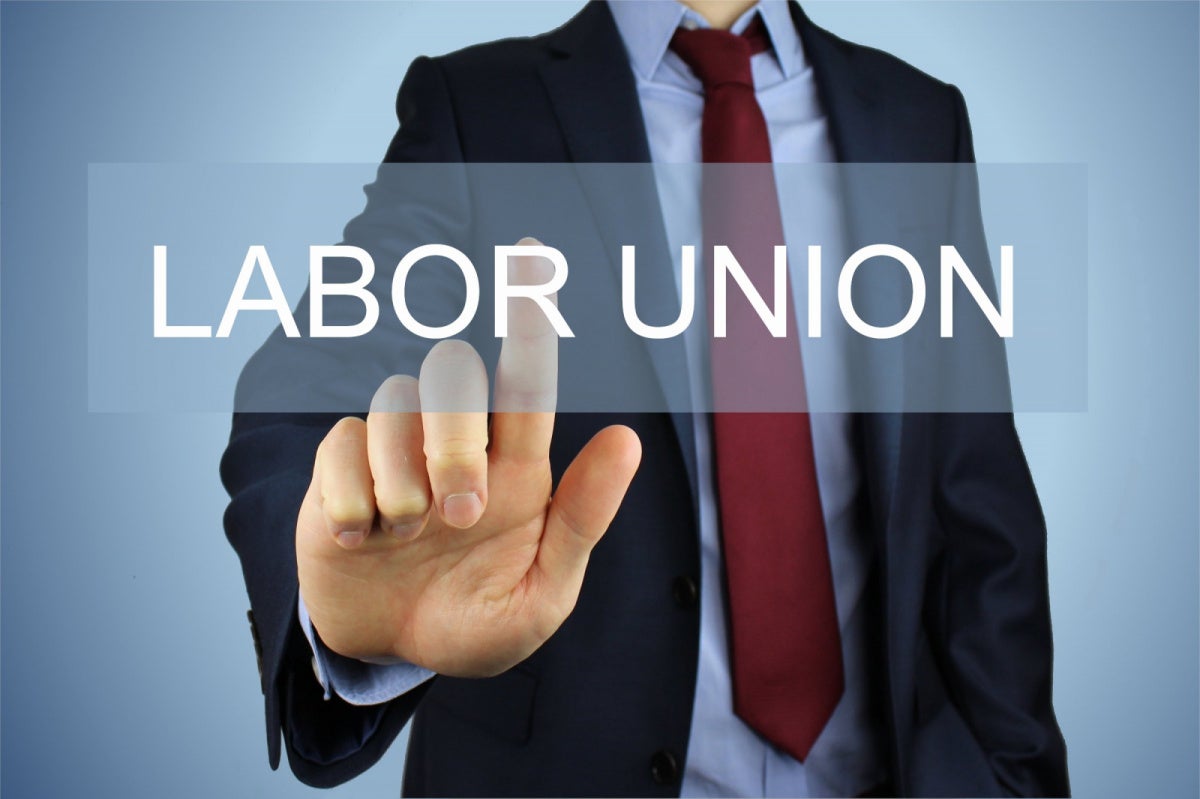 Sphere Las Vegas Warehouse Workers Vote to Join Teamsters Businessman touching a translucent "Labor Union" text overlay, symbolizing Sphere warehouse workers voting to join Teamsters Local 986