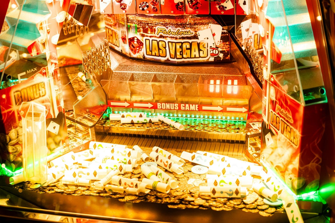 A lit-up Las Vegas-themed slot machine bonus game display with gold coins