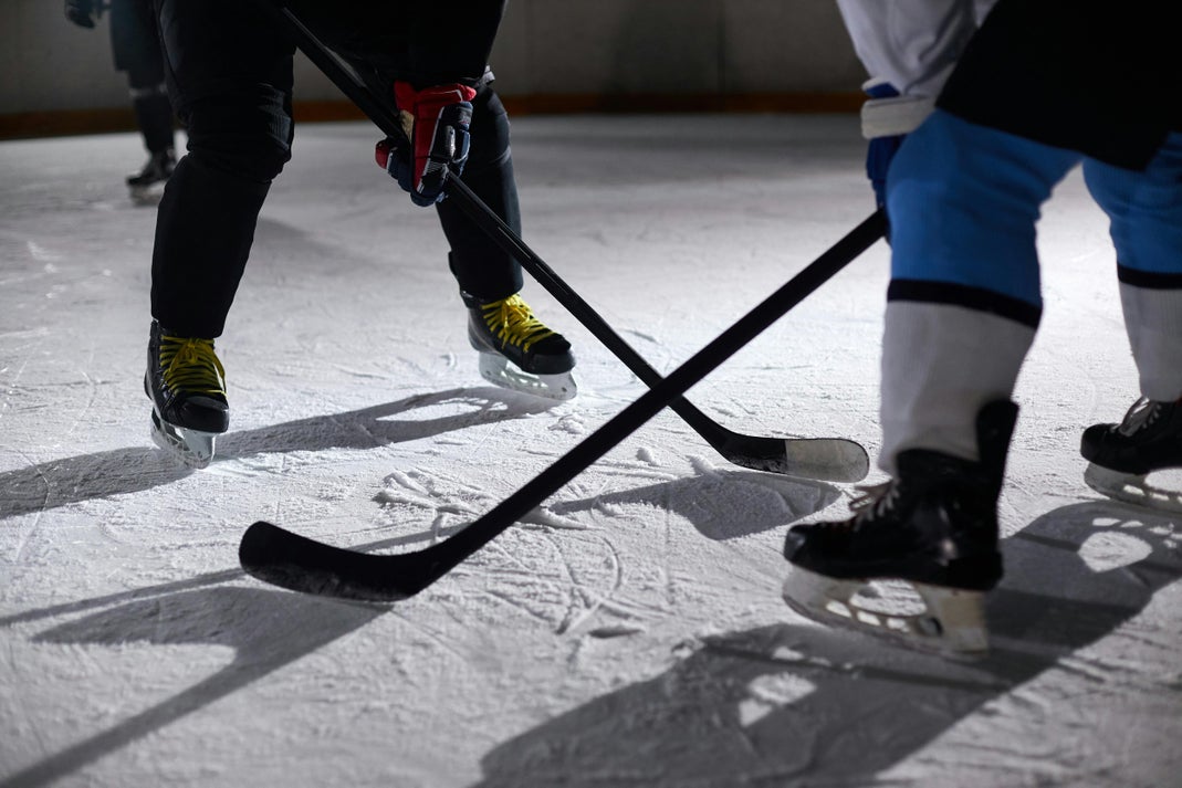 Dominique DiDia Named First-Ever GM of PWHL Las Vegas Close-up of hockey players battling for puck during an intense face-off on a lighted ice rink