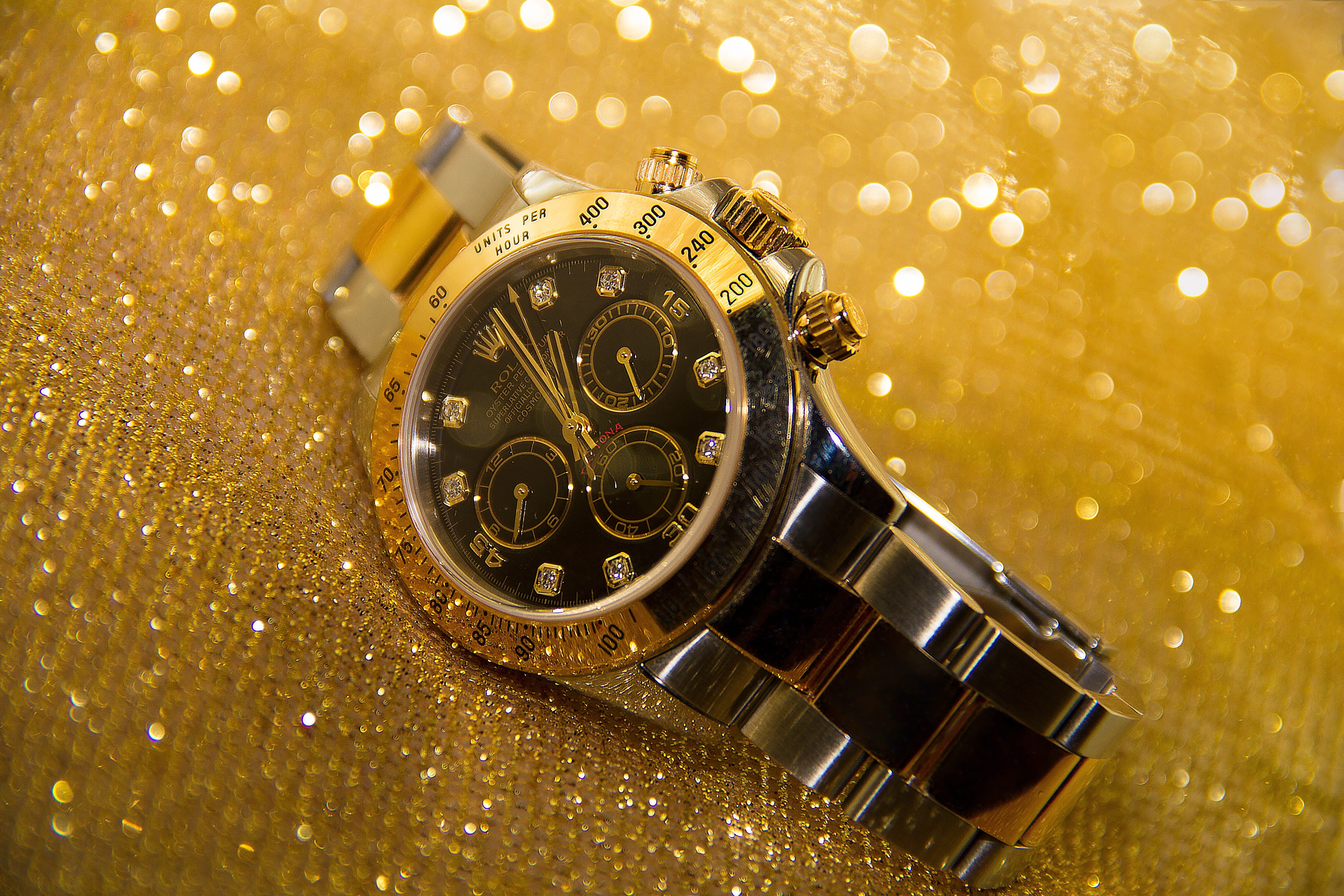 The Escapement Watch Event Debuts in Las Vegas Feb. 2027 Luxury two-tone chronograph watch resting on a gold glitter background