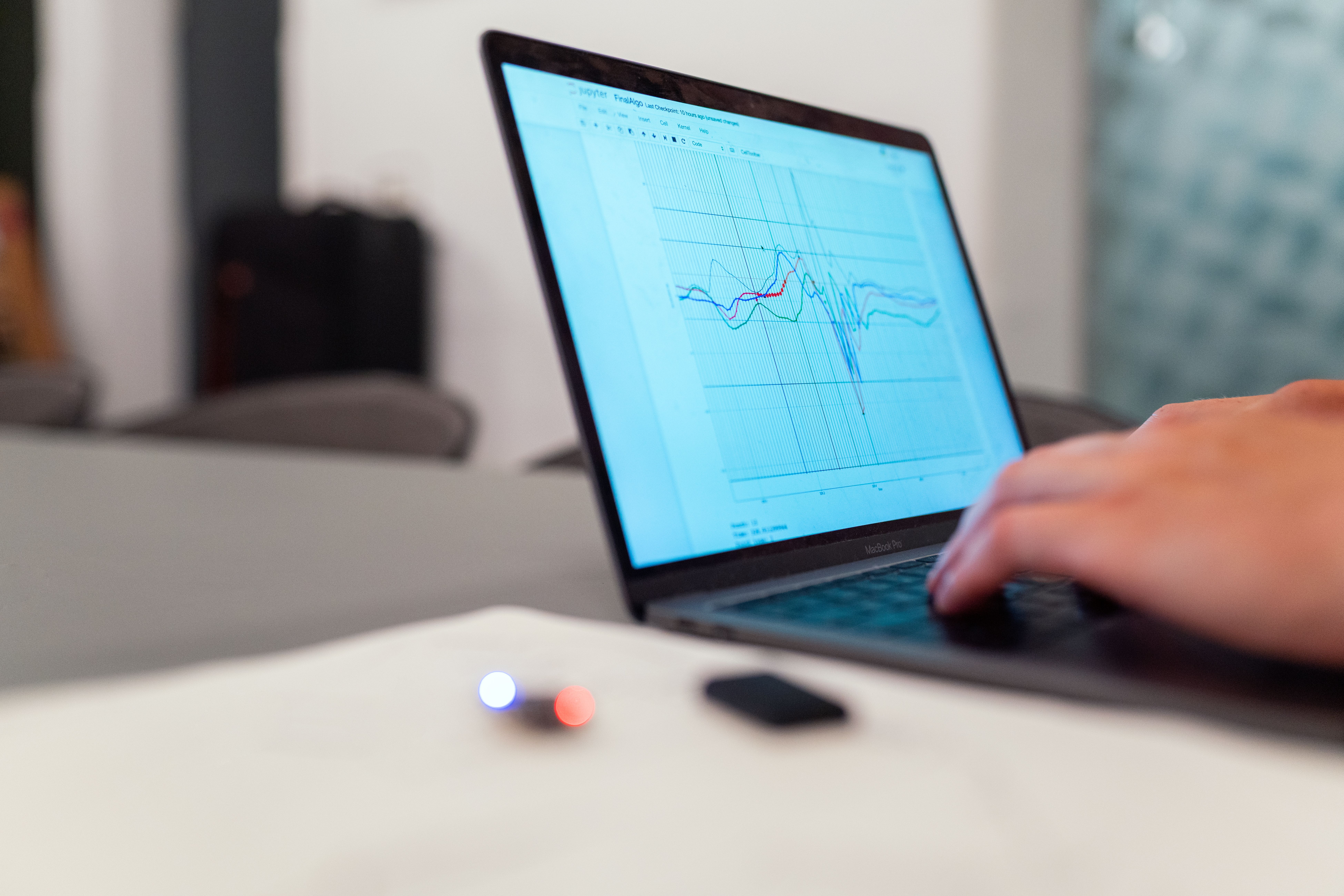 Canada Prediction Markets: Lottery Group Wants Tougher Rules Laptop displaying a colorful data graph with a hand typing on the keyboard, symbolizing financial analysis and prediction markets