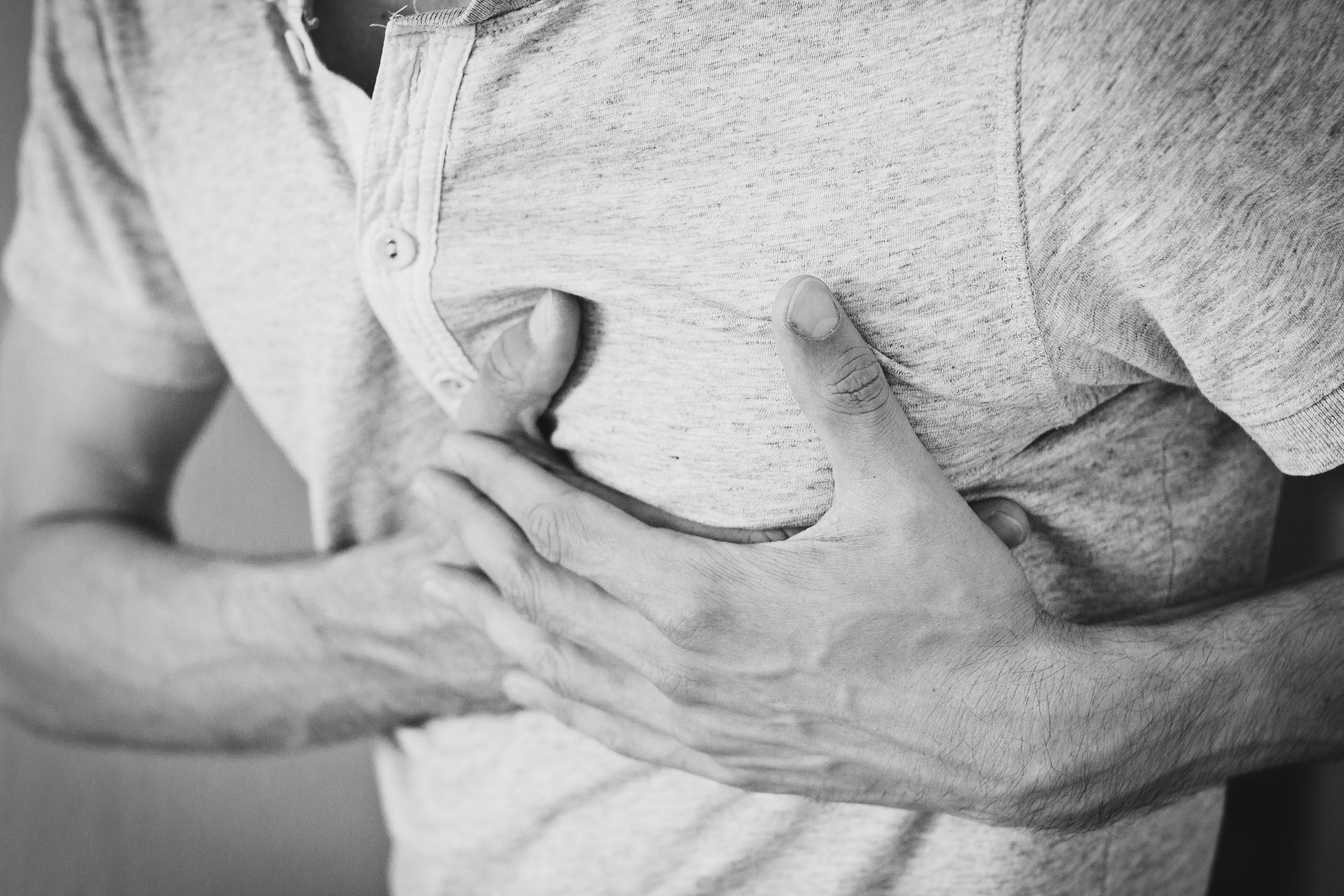 Wynn Las Vegas Lawsuit: Guest Alleges Legionnaires' Case Man clutching chest in pain, symbolizing health issues such as Legionnaires’ disease or severe pneumonia