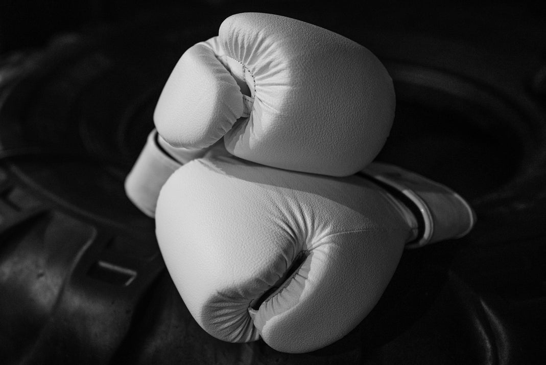 White boxing gloves resting on a dark surface
