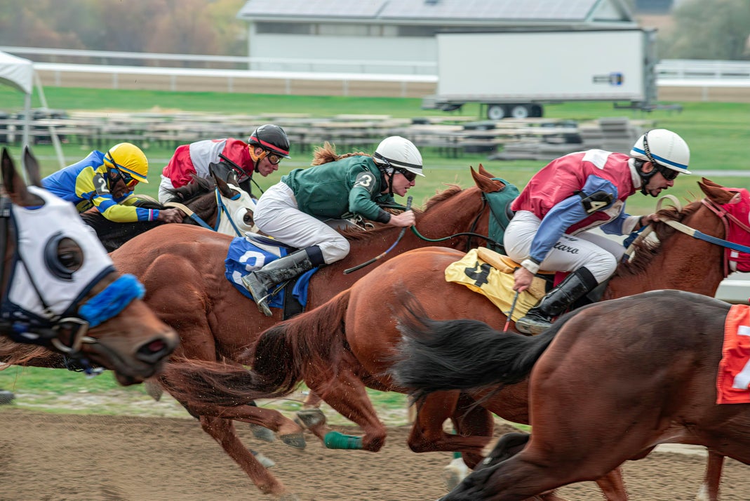 Jockeys riding horses in a close competitive race at a racetrack
