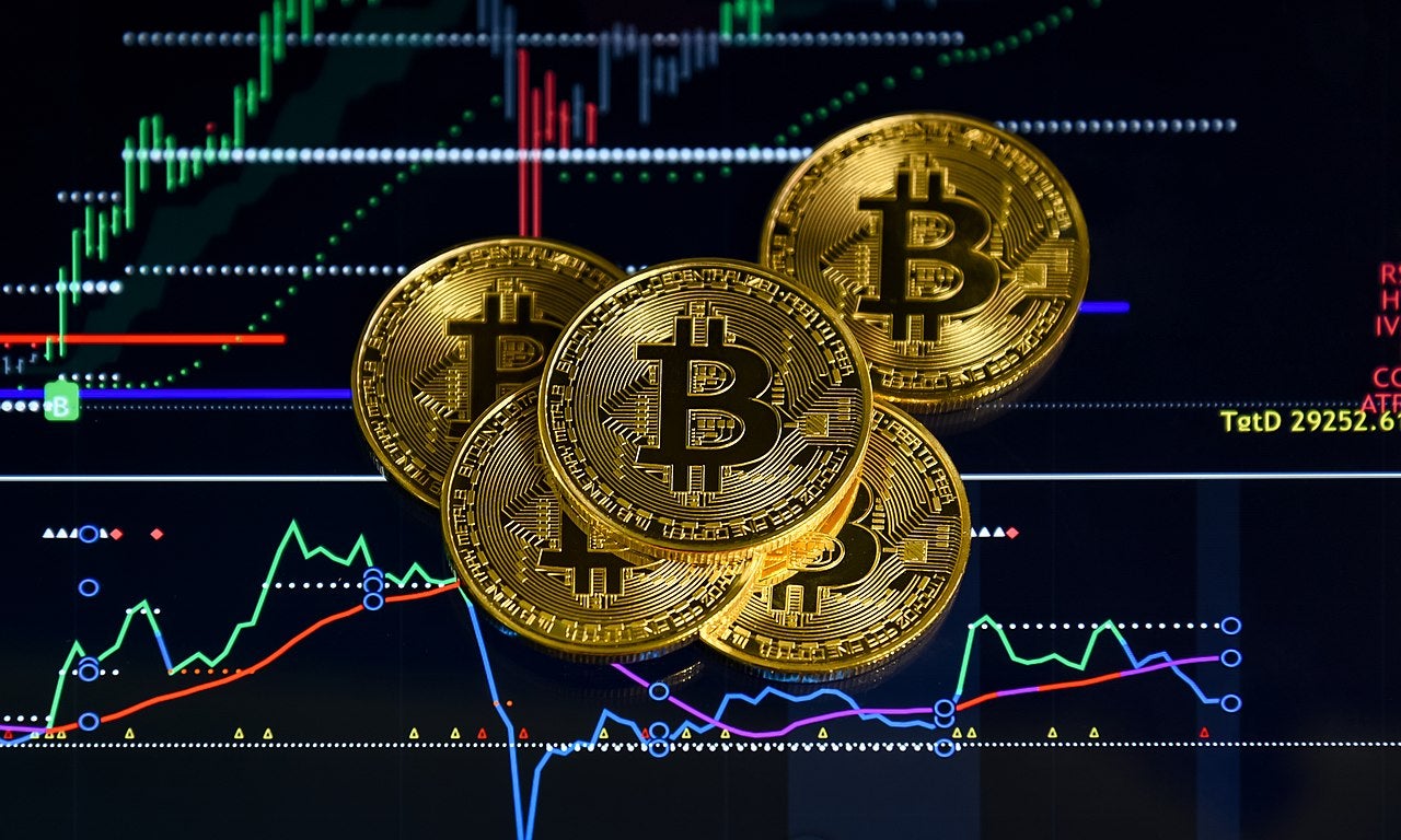 Bitcoin Coins with Crypto Trading Chart Market Analysis Gold Bitcoin coins placed on a digital trading chart showing cryptocurrency market trends and price movements