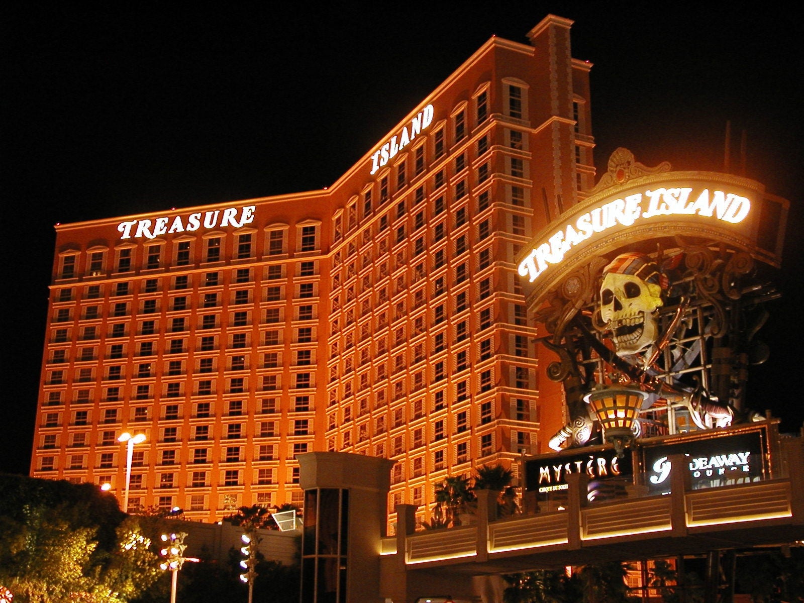 Treasure Island casino sign lit up at night on the Las Vegas Strip