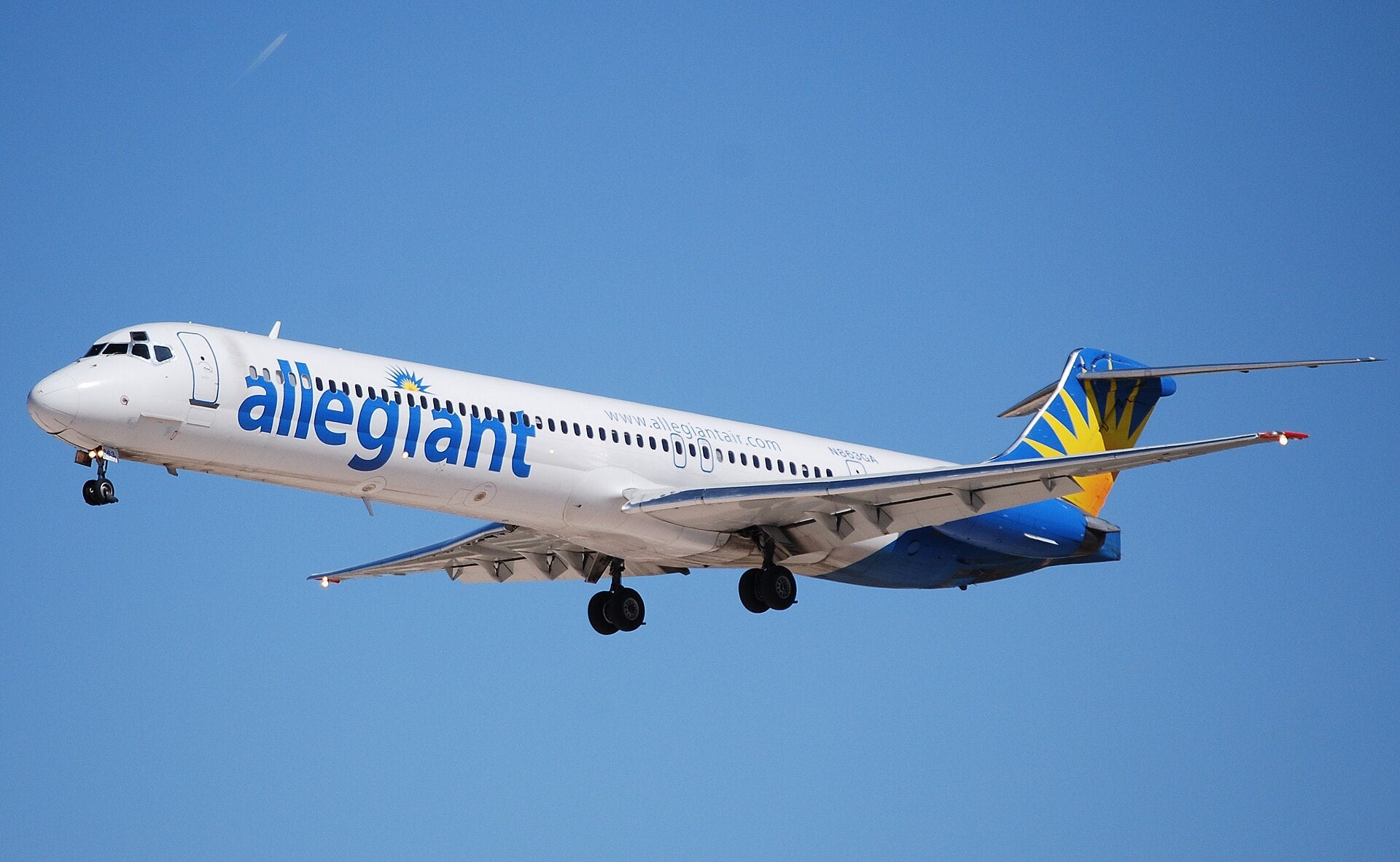 Allegiant Air aircraft on approach to landing against a clear blue sky