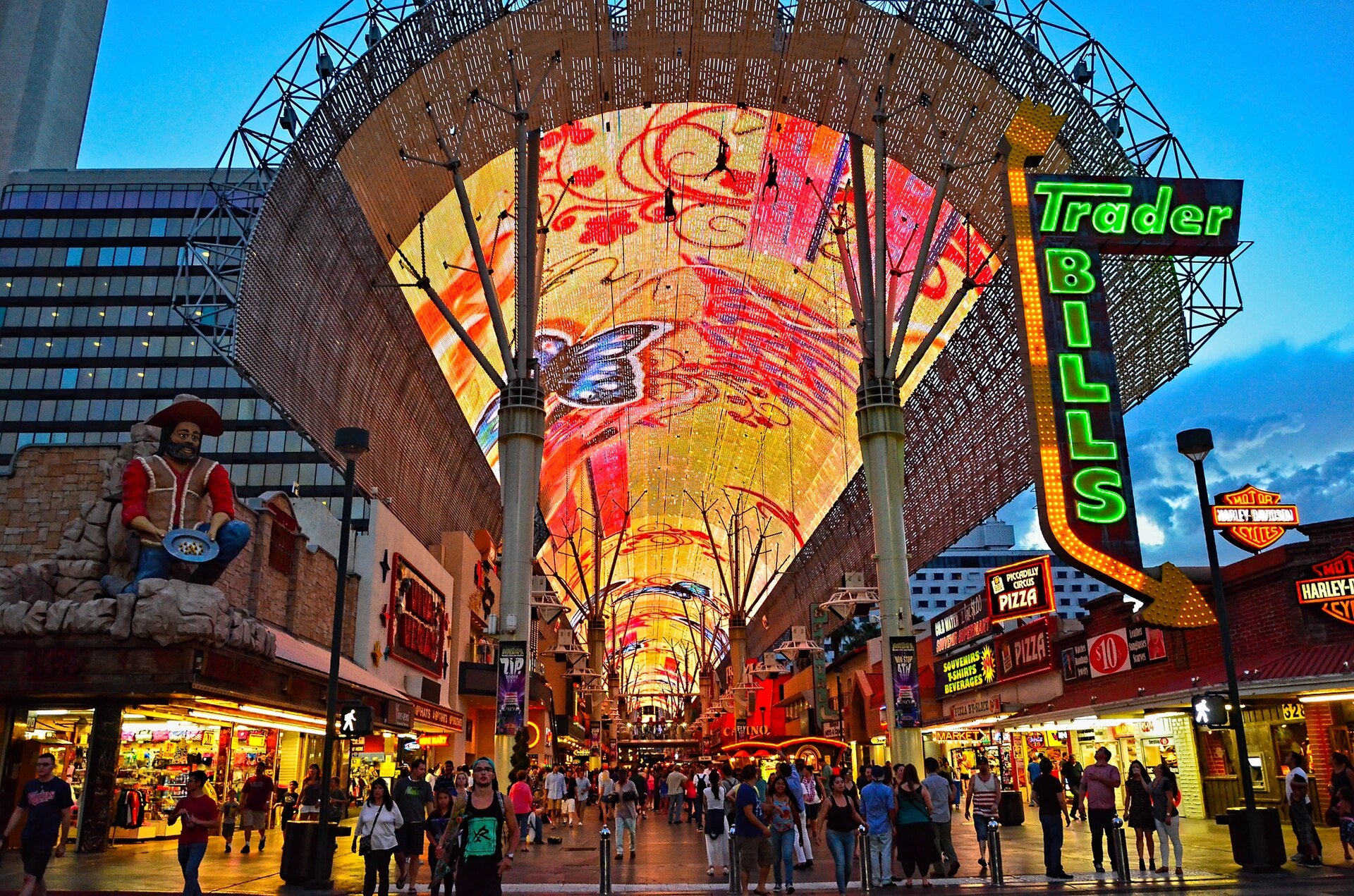 Crowds walking under the LED canopy at Fremont Street Experience in downtown Las Vegas at dusk