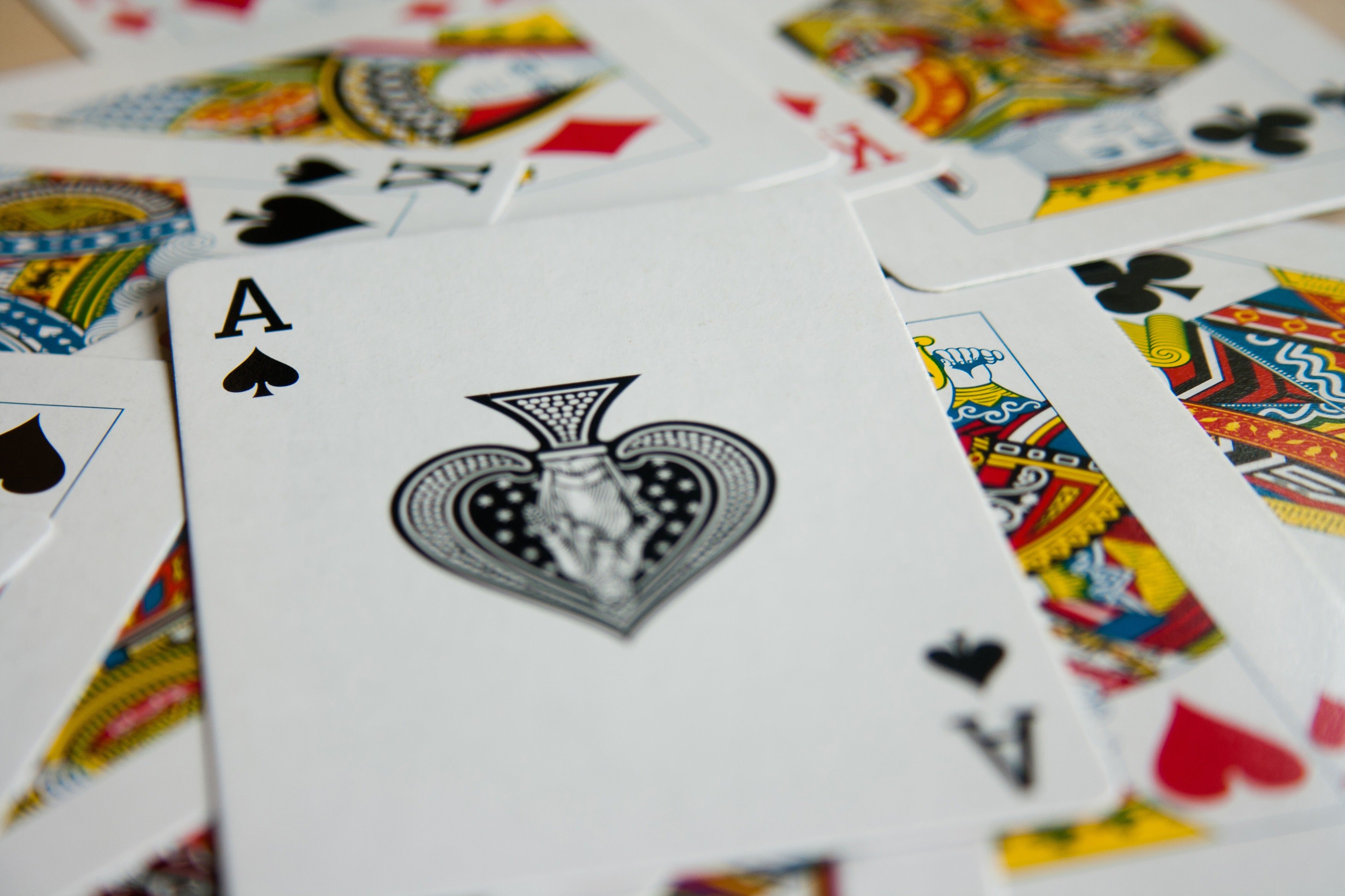 Spread of playing cards including the Ace of Spades, representing Alberta's regulated online gambling market