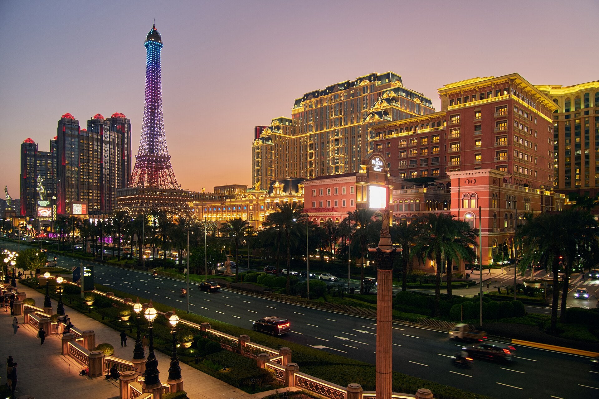 Macau GDP Seen Falling 2% in Q3 as Casino Slump Spreads Casino resorts on Macau's Cotai Strip at dusk, including the Parisian Macao's illuminated Eiffel Tower replica and The Plaza Macao