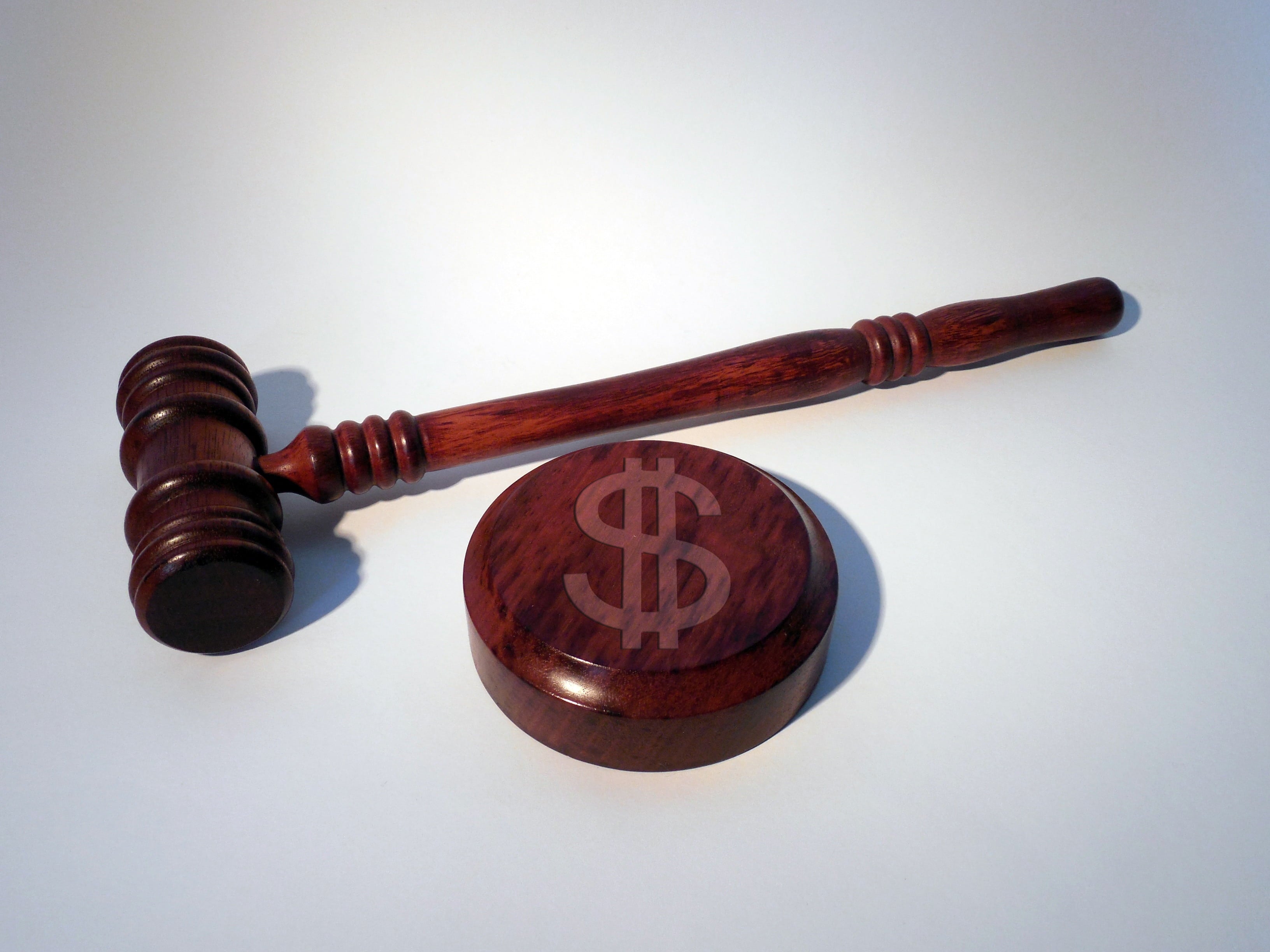 Wooden gavel next to a block engraved with a dollar sign, representing the AGCO's CA$70,000 fine against Booming Games