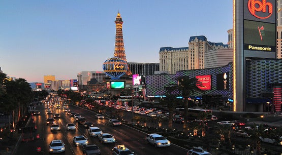 Traffic on the Las Vegas Strip at sunset with the Paris Las Vegas Eiffel Tower and casino resorts illuminated