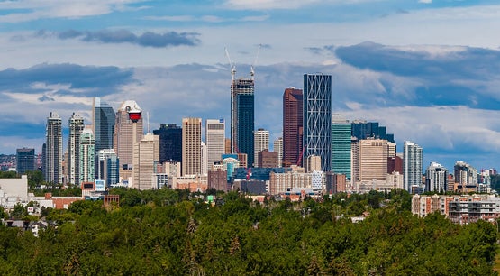 Panoramic view of Calgary skyline with downtown skyscrapers and cloudy sky in Alberta, Canada