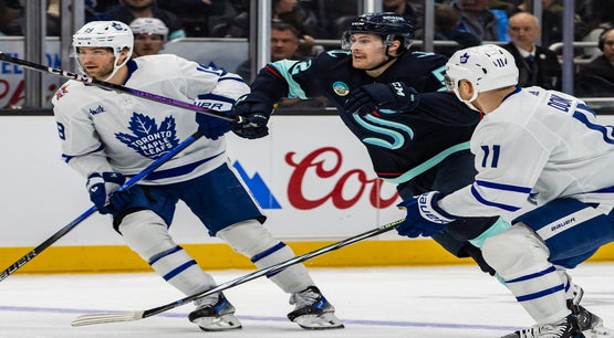 Toronto Maple Leafs players Calle Järnkrok and Max Domi in action against Seattle Kraken's Tye Kartye during an NHL game in January 2024