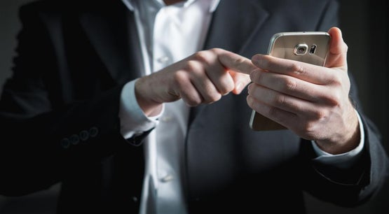 A person in a suit using a mobile phone