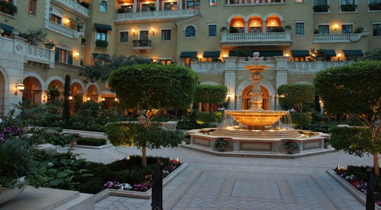 The Mansion at MGM Grand Las Vegas The courtyard of the MGM Grand Mansion in Las Vegas, featuring a lit fountain, manicured trees, and the facade of the upscale private retreat