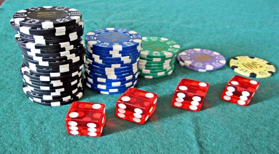 PAGCOR Remits PHP5.67B in Dividends to National Treasury Red dice and stacks of casino chips on a green felt table