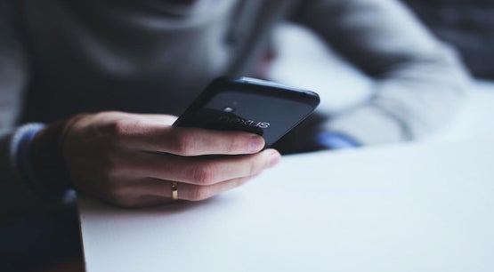 Alberta iGaming Launch: Regulated, Safe, and Open July 13 Person holding a black Nexus smartphone at a desk