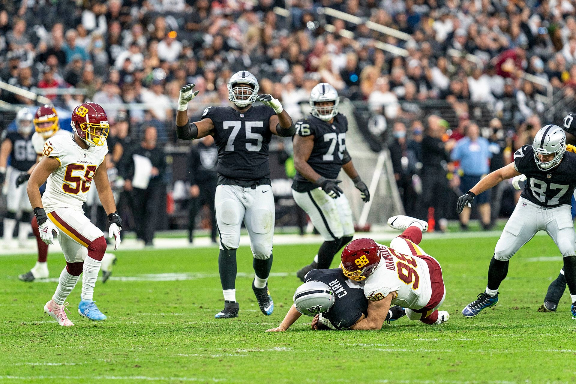 Tom Brady Raiders Ownership: OTA Presence & Impact Washington Football Team defensive end Matt Ioannidis sacks Las Vegas Raiders quarterback Derek Carr during an NFL game in December 2021