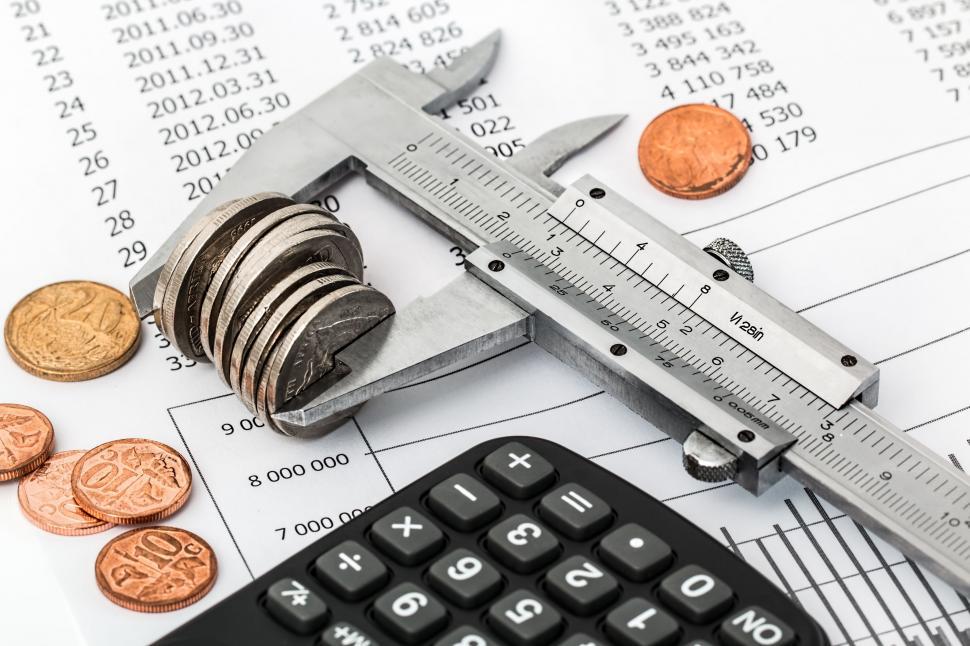 Great Canadian Entertainment Fined $120K by Ontario AGCO Coins, a calculator, and calipers on financial spreadsheet data, illustrating a casino regulatory penalty