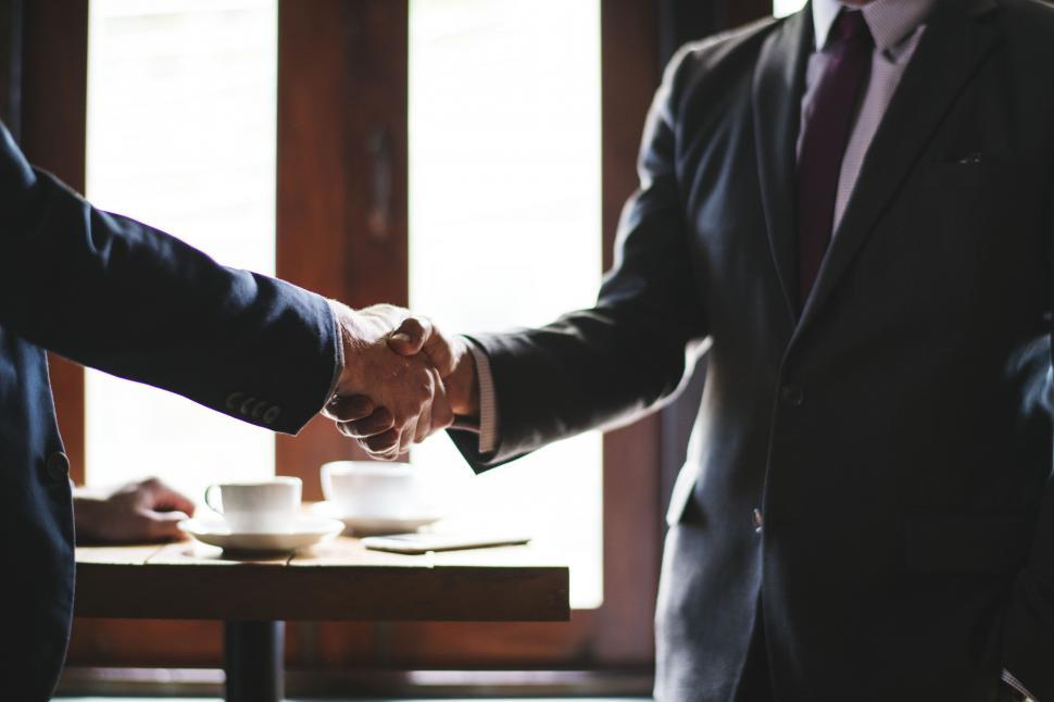 Two business executives shaking hands over a partnership deal, representing the Incentive Games and bet365 Alberta agreement
