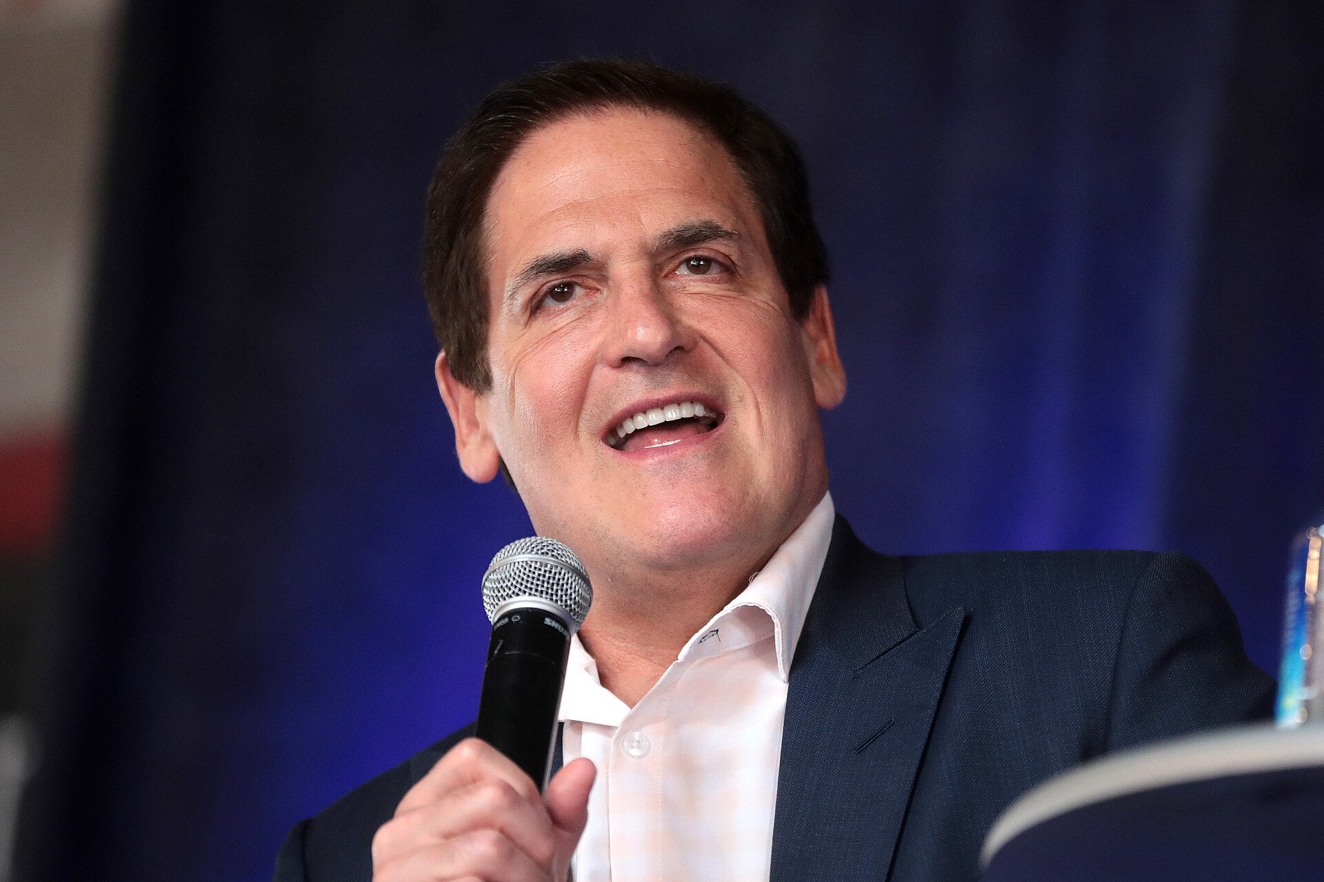Mark Cuban's Harbinger Buys Stake in Athletics for $50M Mark Cuban speaking into a microphone at an event, representing Harbinger Sports Partners' investment in the Athletics